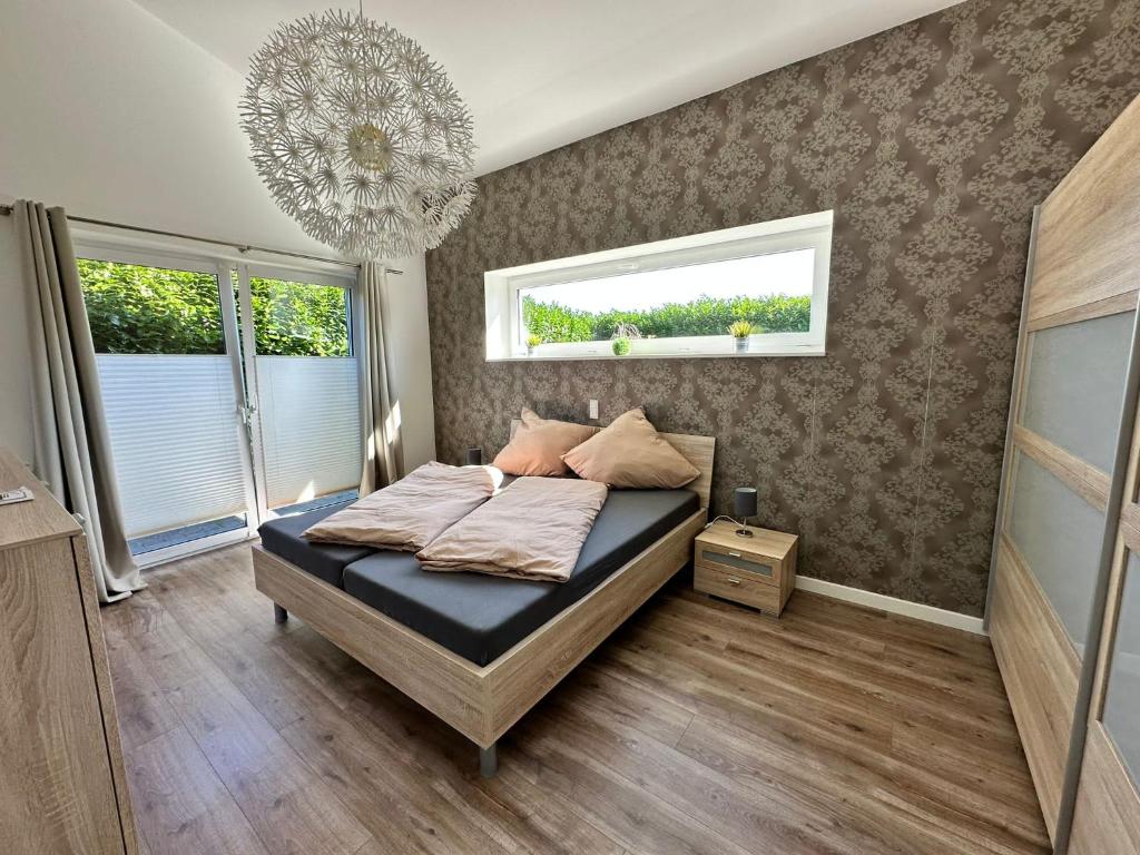 Schlafzimmer mit einem Bett und einem Kronleuchter in der Unterkunft Idylisches Ferienhaus in Edewecht