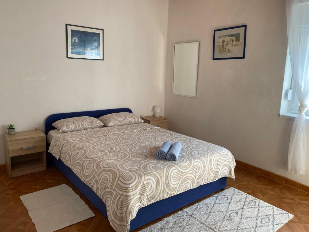 a bedroom with a bed with two blue shoes on it at Ždrelac Guest House in Ždrelac