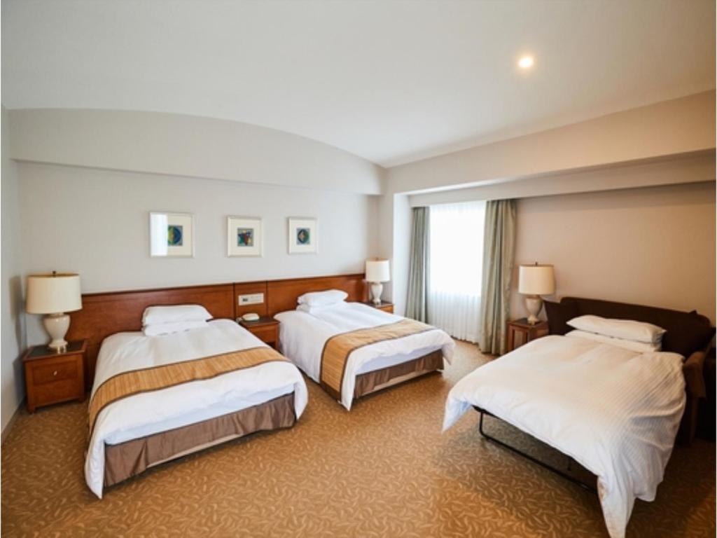 Habitación de hotel con 3 camas y ventana en Hotel Terrace The Square Hitachi - Vacation STAY 21932v, en Hitachi