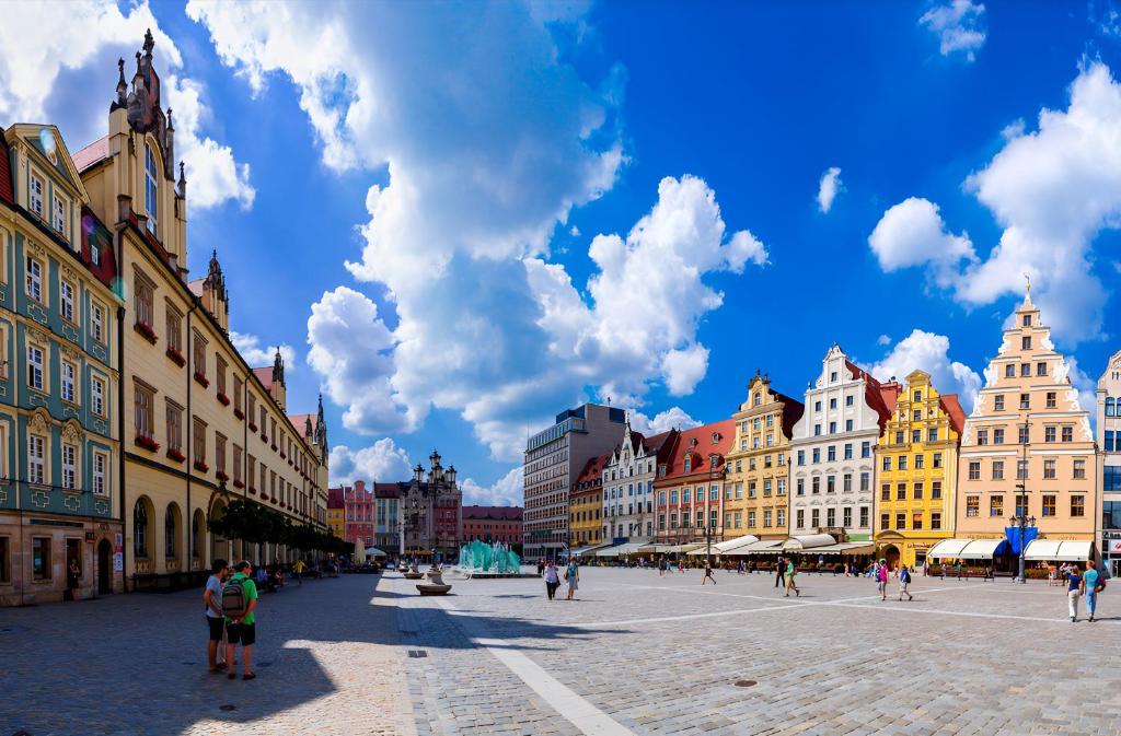 a group of people walking around a city street at Cozy Flat in Rynek in Wrocław