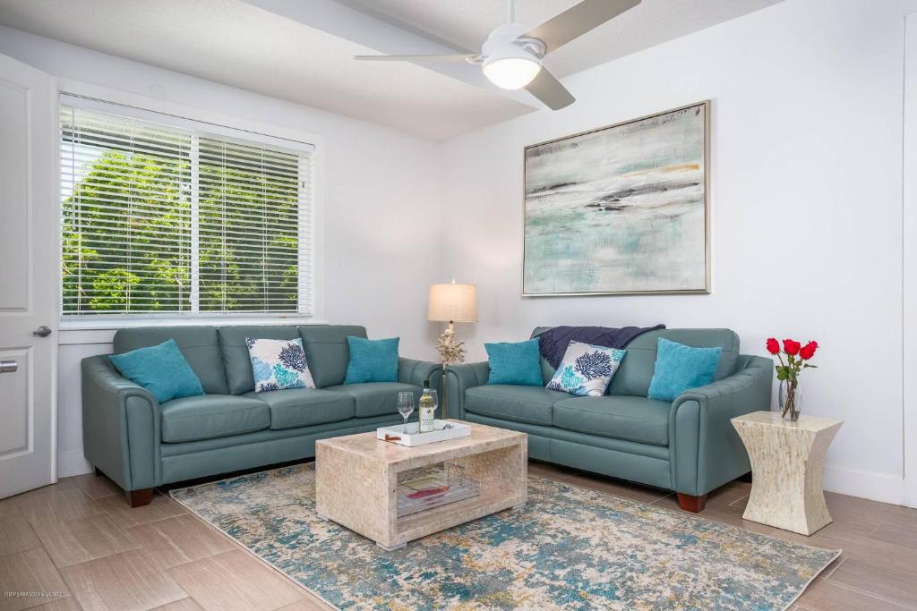 a living room with two blue couches and a table at Lido Dream Getaway Duplex N in Sarasota