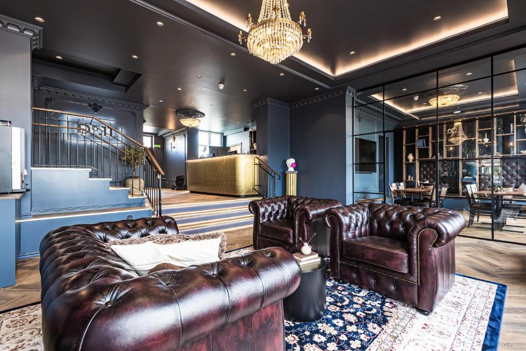 a living room with leather furniture and a chandelier at Hotell Drottninggatan 11 in Boden