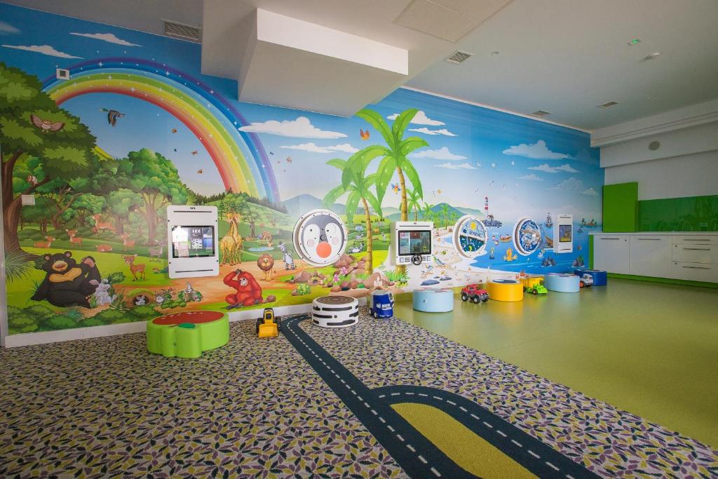 a childrens room with a rainbow mural on the wall at Grand Lubicz Uzdrowisko Ustka in Ustka
