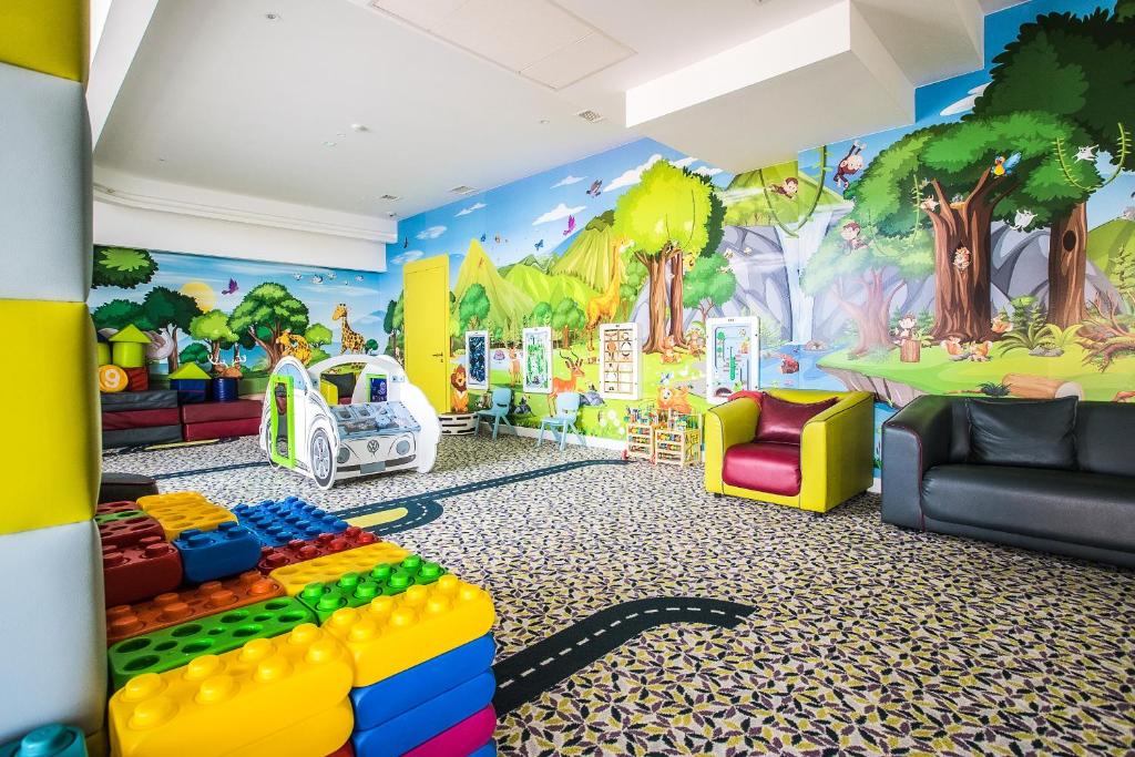 a childs play room with a wall mural of trees at Grand Lubicz Uzdrowisko Ustka in Ustka