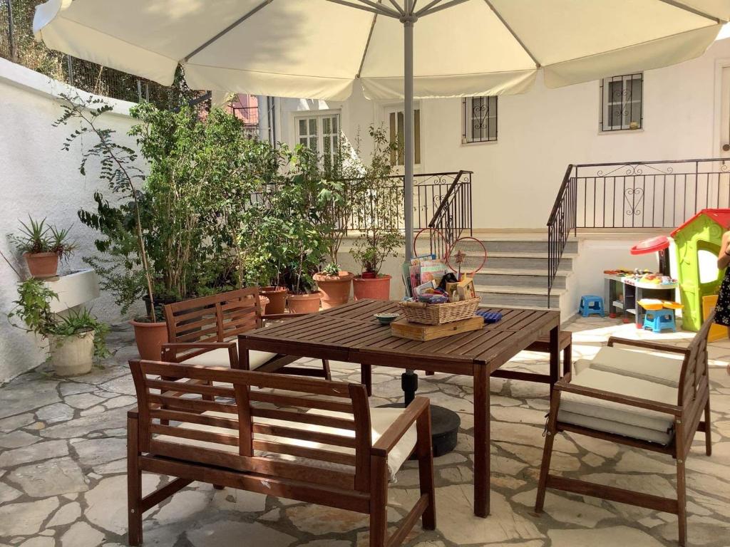 a table and two chairs and an umbrella on a patio at DVLNG FAMILY STUDIO APARTMENT in Kassiopi