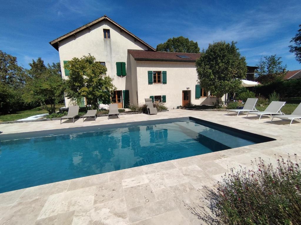 a swimming pool in front of a house at Le Tilleul in Sciez