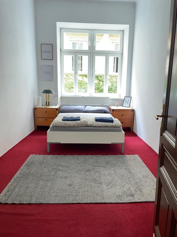 a bedroom with a bed and a large window at Volkstheater Apartment. in Vienna