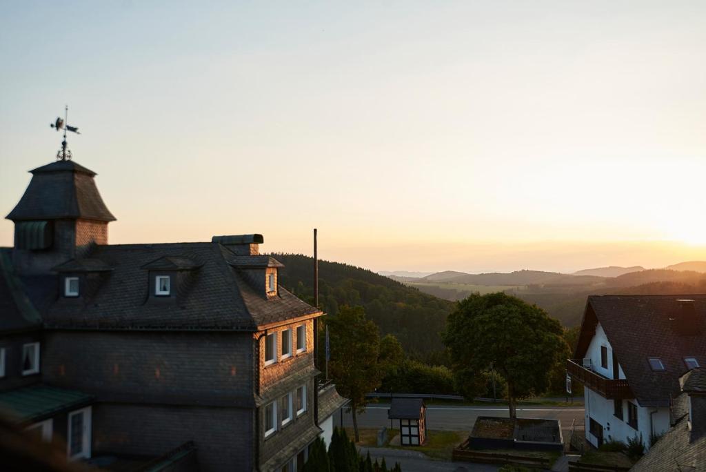 un antiguo edificio con una torre encima en Romantik Berghotel Astenkrone, en Winterberg