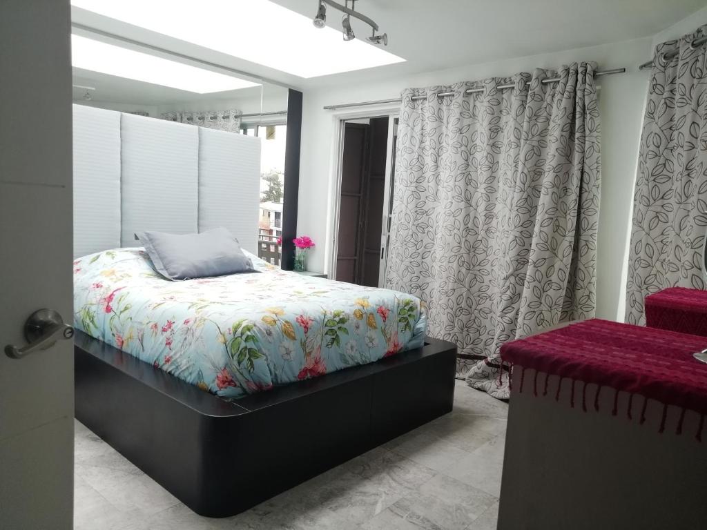 Schlafzimmer mit einem Bett und einem Fenster in der Unterkunft Totonaca - Seguridad, 10min de Centros Comerciales & Zona Esmeralda - Empresas bienvenidas in Mexiko-Stadt