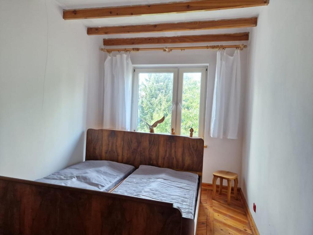 ein Schlafzimmer mit einem Holzbett und einem Fenster in der Unterkunft Artapartamenty in Rzeszów