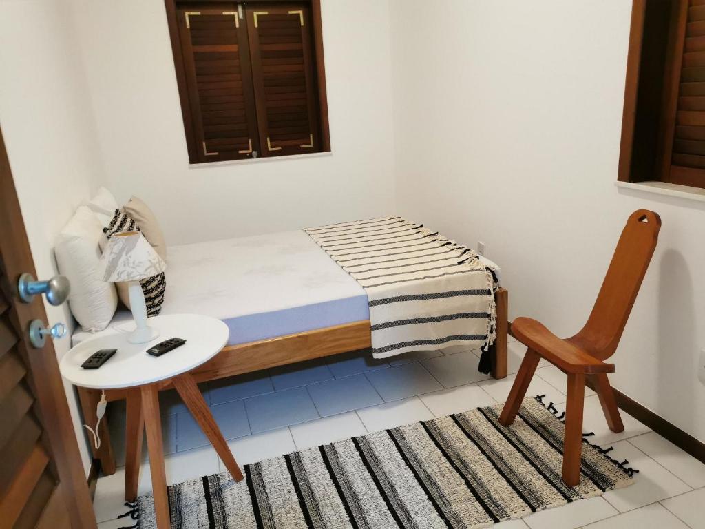 a small bedroom with a bed and a chair at Lagoa dourada - Ilha de Itaparica - Salvador da Bahia - Club Med in Vera Cruz de Itaparica