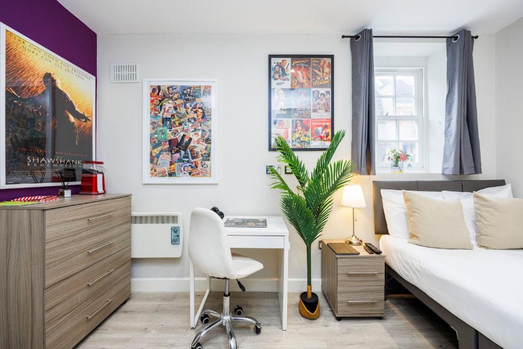 a bedroom with a bed and a desk and a chair at Quality Spitalfields Accommodations in London