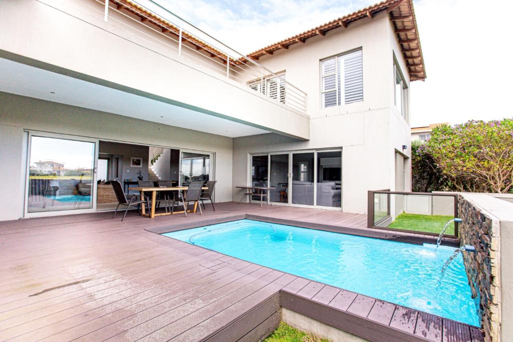 a house with a swimming pool and a patio at Sunset Golf Villa in Langebaan