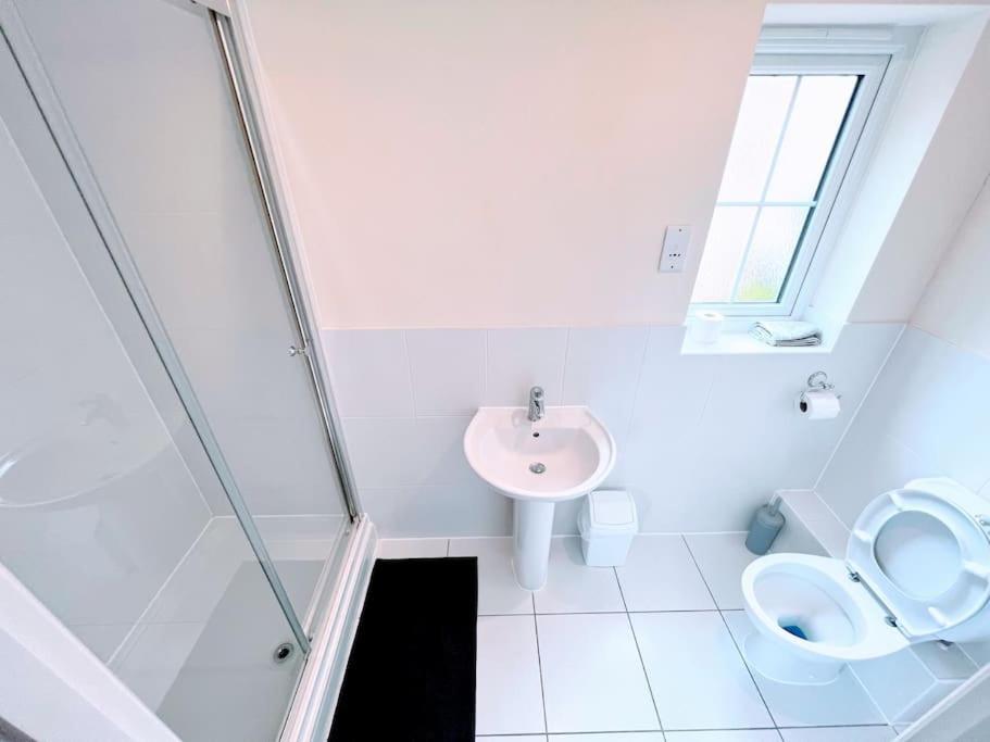 uma casa de banho branca com um lavatório e um WC em Astor house Maidstone long stay em Maidstone