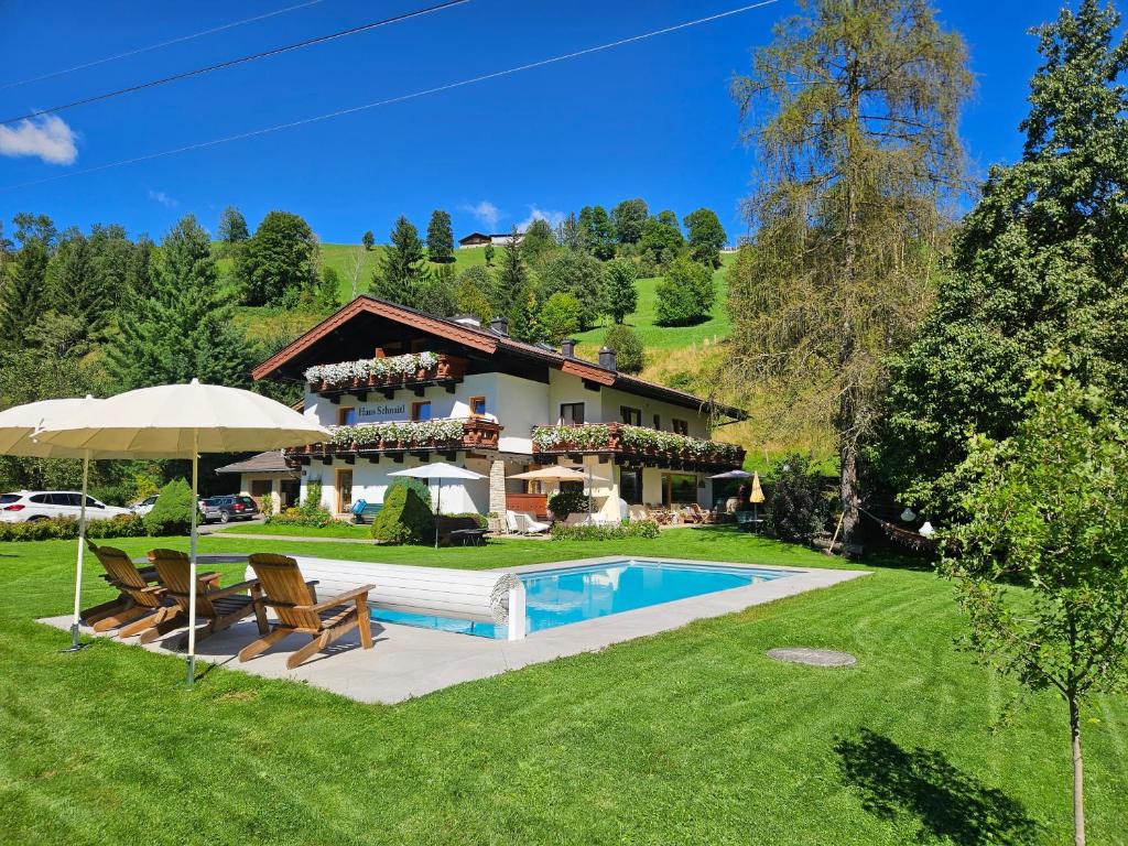a house with a swimming pool in a yard at Pension Schnaitl in Maria Alm am Steinernen Meer