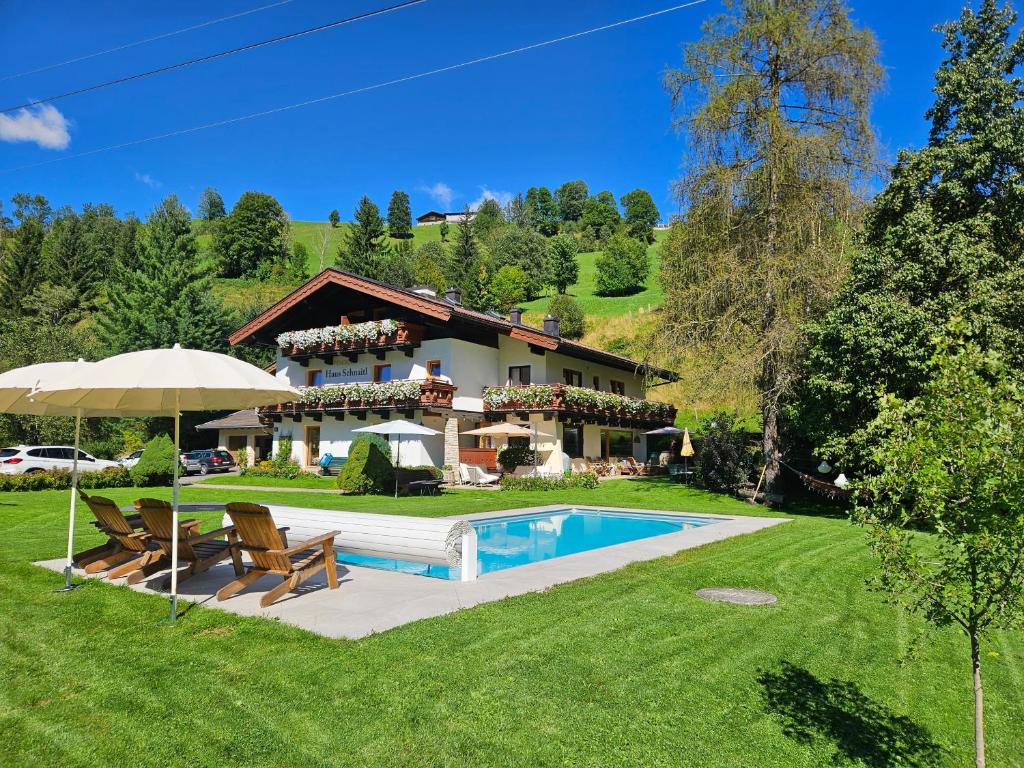 ein Haus mit einem Pool im Hof in der Unterkunft Pension Schnaitl in Maria Alm am Steinernen Meer