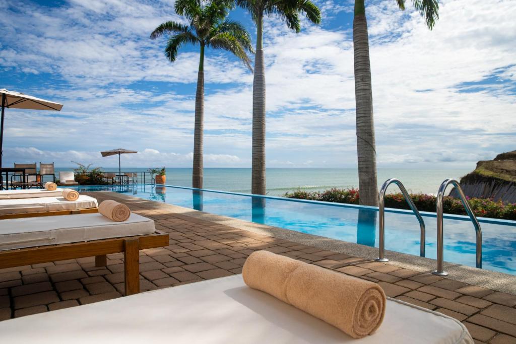 a resort infinity pool with a view of the ocean at Jama Campay - Homes Resort & Spa in Jama