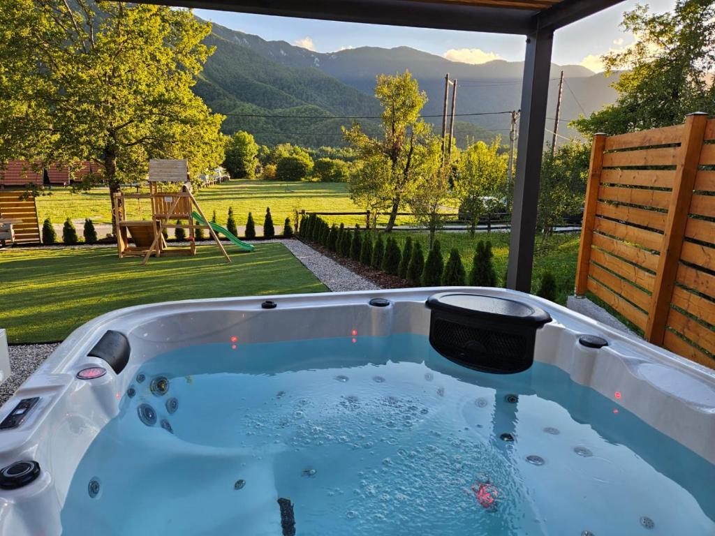 a jacuzzi tub with a view of a yard at Oak House in Brušane