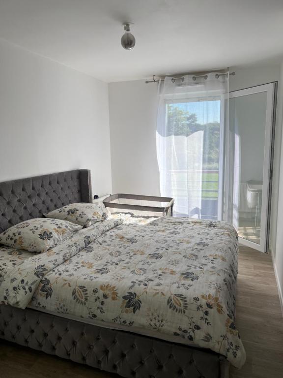 a bedroom with a bed and a large window at Appartement tout équiper in Orléans