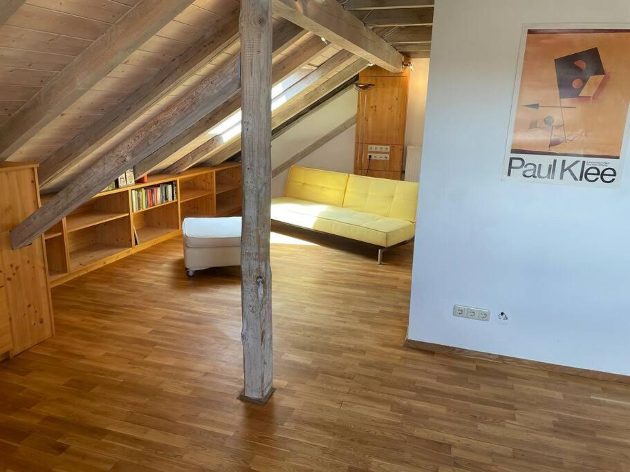 a living room with a yellow couch in a attic at Sonnige Ferienwohnung Maja in Heroldsberg