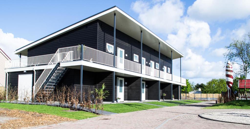 een zwart-wit gebouw met een balkon bij De Berkenhof Aparthotel in Nes