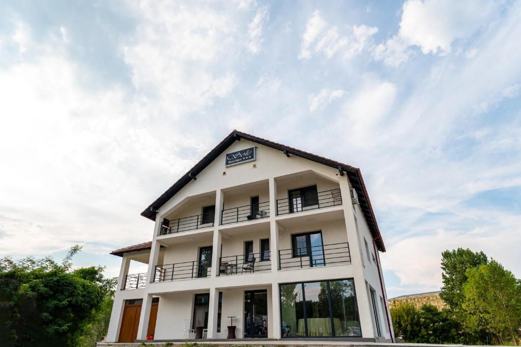 a white building with a sky in the background at Sole Boutique in Râmnicu Vâlcea