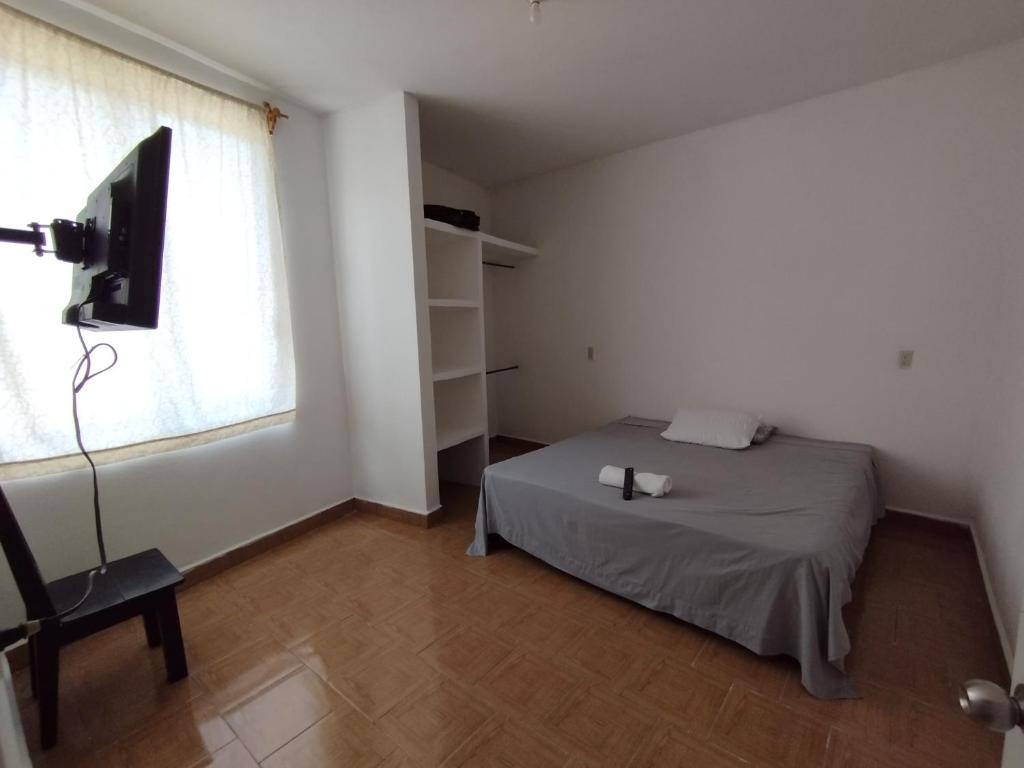 a bedroom with a bed and a tv and a window at No disponible in Xilitla