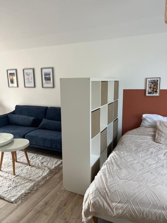 ein Schlafzimmer mit einem Bett, einer Couch und einem Tisch in der Unterkunft DisneylandParis Cosy indépendance in Chalifert