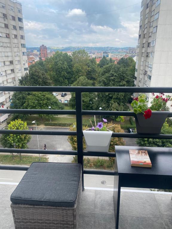 d'un balcon avec un banc et une vue sur la ville. dans l'établissement Apartman Una, à Čačak