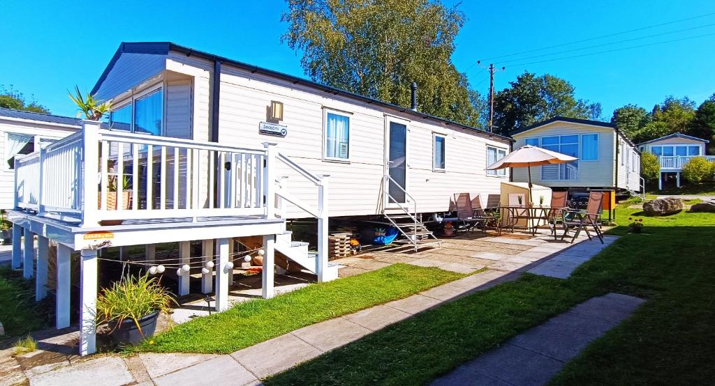 a white tiny house with a deck and a patio at Haven Rockley Park, Lytchett Bay View, Private Holiday Home - Caravan in Lytchett Minster