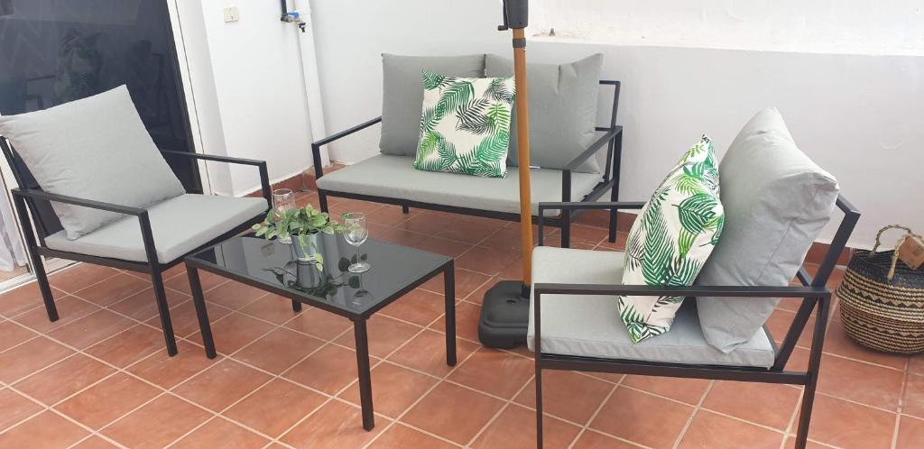 Ático carrizal في Carrizal: فناء مع كرسيين وطاولة مع مخدات