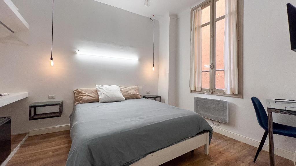 een slaapkamer met een bed, een bureau en een raam bij Chambre moderne, proche Monaco in Beausoleil