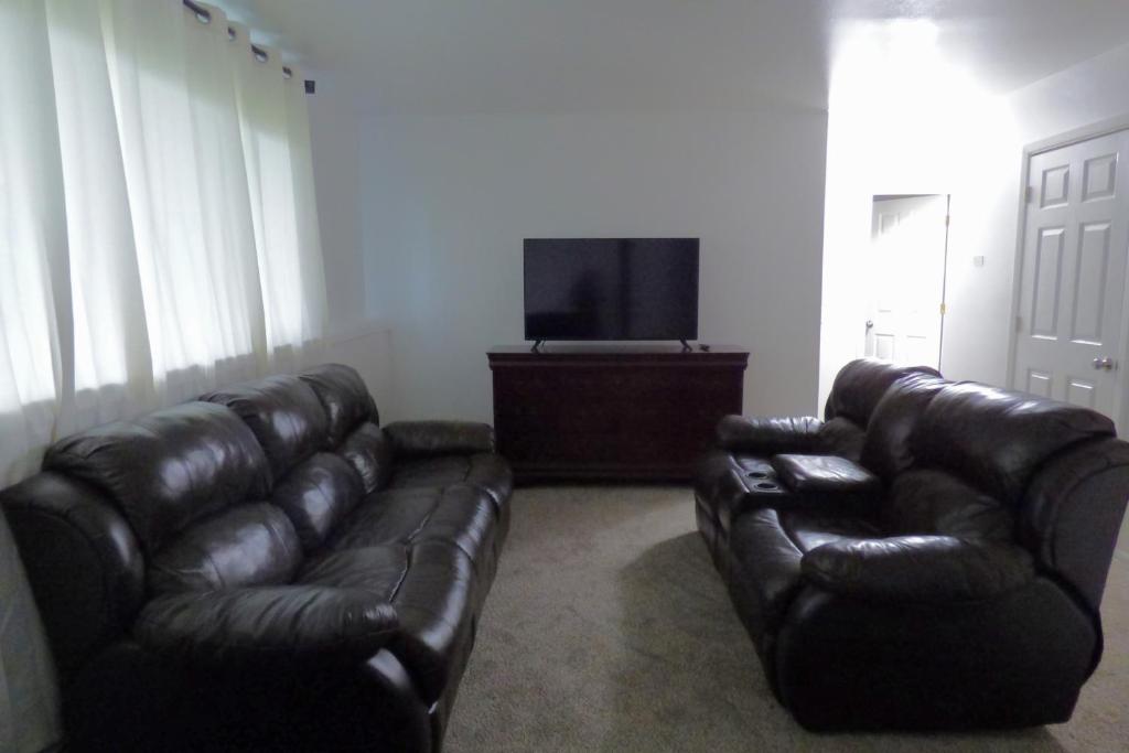salon ze skórzaną kanapą i telewizorem z płaskim ekranem w obiekcie 410 E 45th Unit 1 w mieście Anchorage