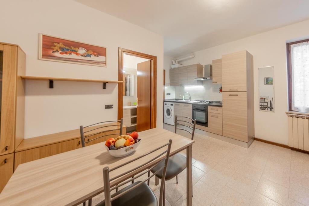 cocina y comedor con mesa y sillas en Casa Olga - Bilocale con terrazzo zona fiera, en Verona
