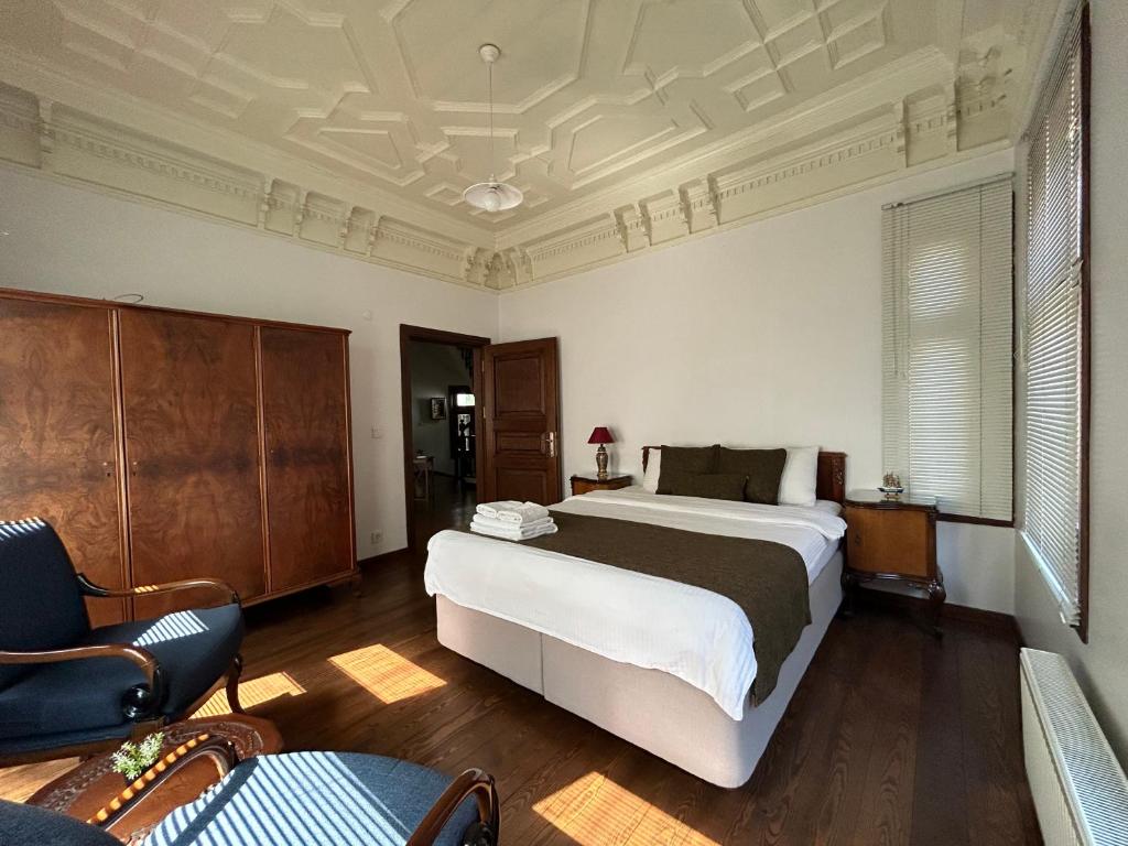 a bedroom with a large bed and a chair at Historic Greek Pavillion Golden Horn Istanbul in Istanbul