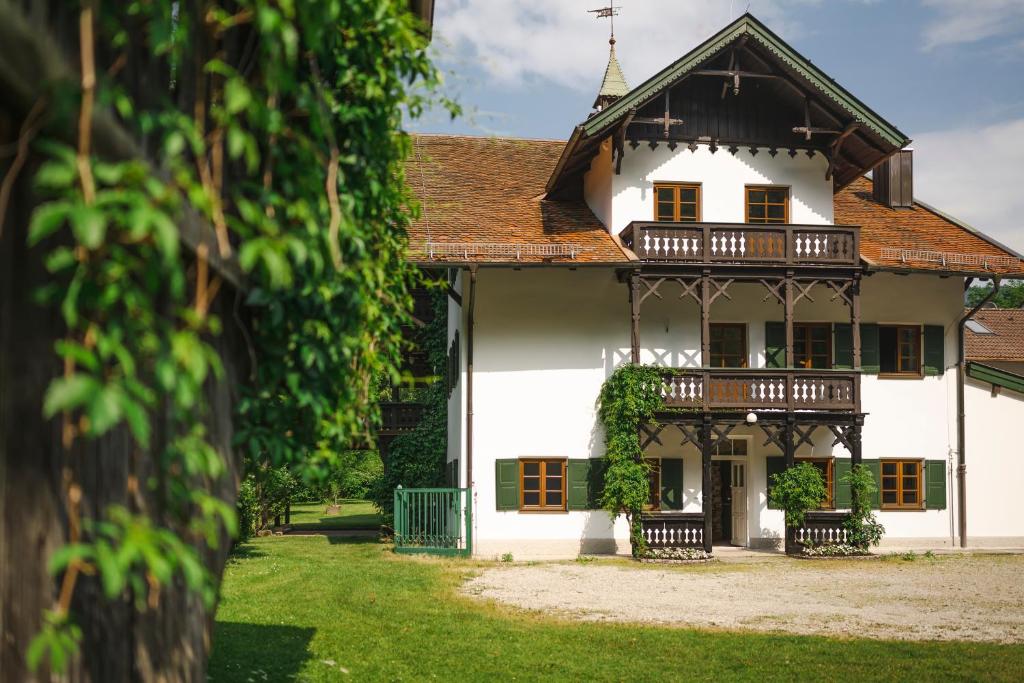 a white house with a porch and a balcony at Mountain Chalet on Gut Buchwies in Oberau