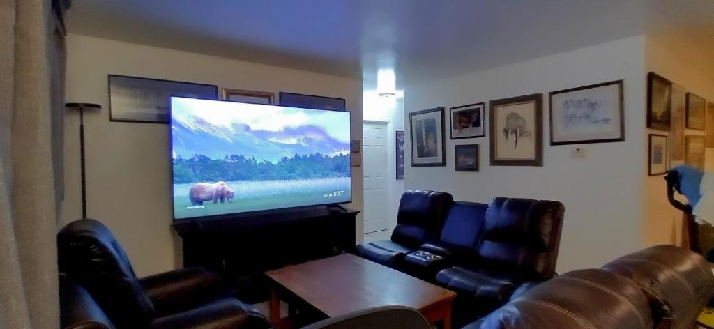 uma sala de estar com uma televisão de ecrã plano e cadeiras de couro em 410 E 45th #3 em Anchorage