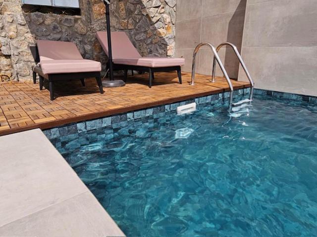 een zwembad met twee stoelen en een zwembad bij Jennas House in Arakapas