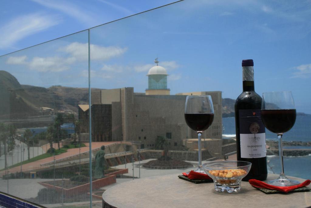 eine Flasche Wein und zwei Gläser auf dem Tisch in der Unterkunft Las Canteras Beach in Las Palmas de Gran Canaria