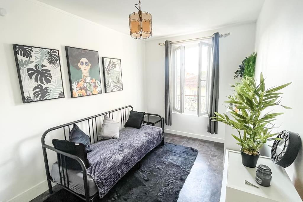 un salon avec un canapé et une plante en pot dans l'établissement Le Comfy Spot - Porte de Paris, à Aubervilliers