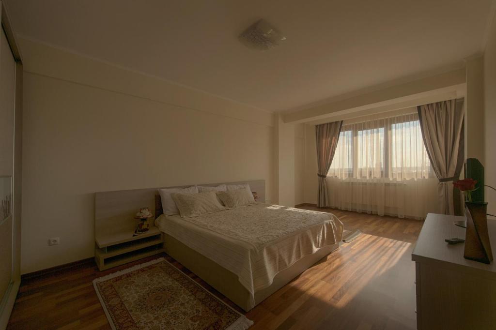 a bedroom with a bed and a large window at Samali Residence in Eforie Nord