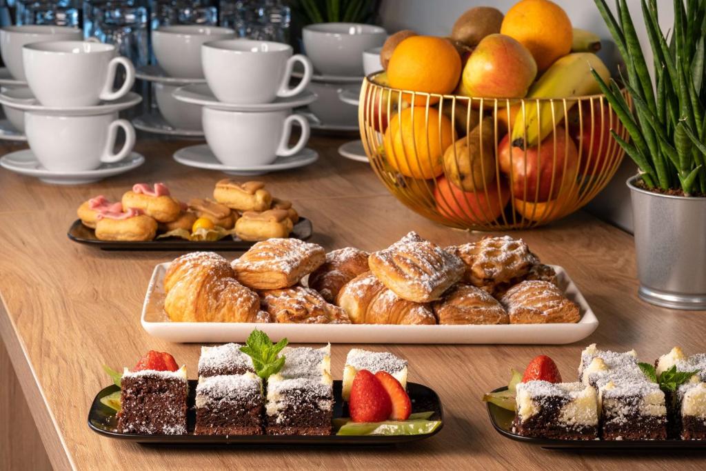a table topped with different types of pastries and fruit at Park Inn by Radisson Vilnius Airport Hotel & Conference Centre in Vilnius