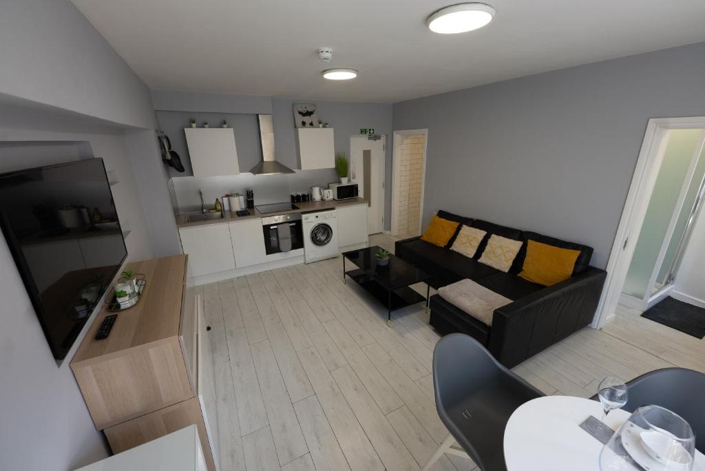 a living room with a couch and a table at Central Brighton modern one bed apartments in Brighton & Hove