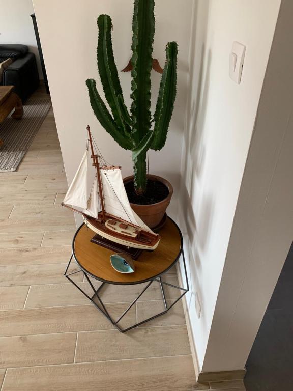 a small wooden boat on a table next to a cactus at Appartement spacieux et lumineux in Sélestat