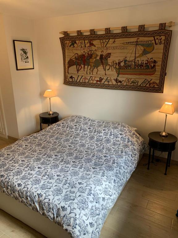 a bedroom with a bed and two tables with lamps at Appartement spacieux et lumineux in Sélestat