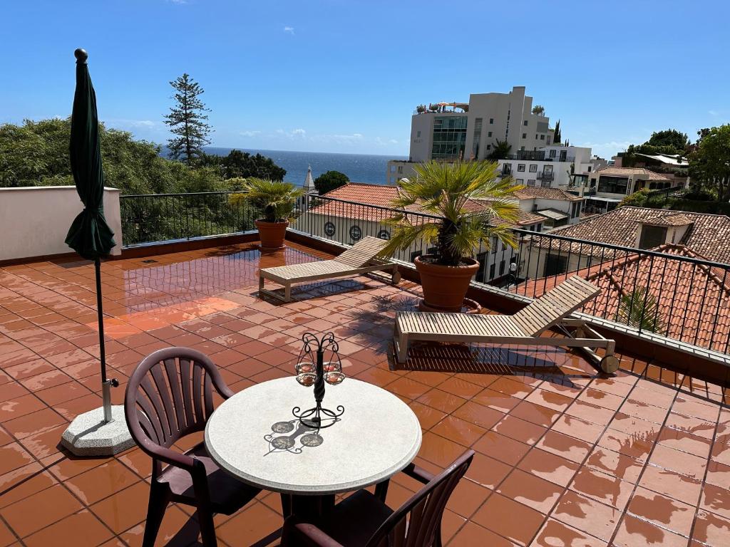 een patio met een tafel en stoelen op een balkon bij Casino Villa with Sea View in Funchal