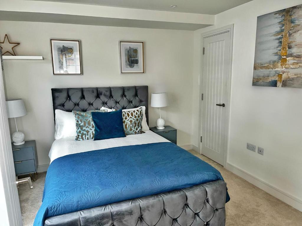 um quarto com uma cama grande e lençóis azuis em Luxury Northampton Town Centre Apartment em Northampton
