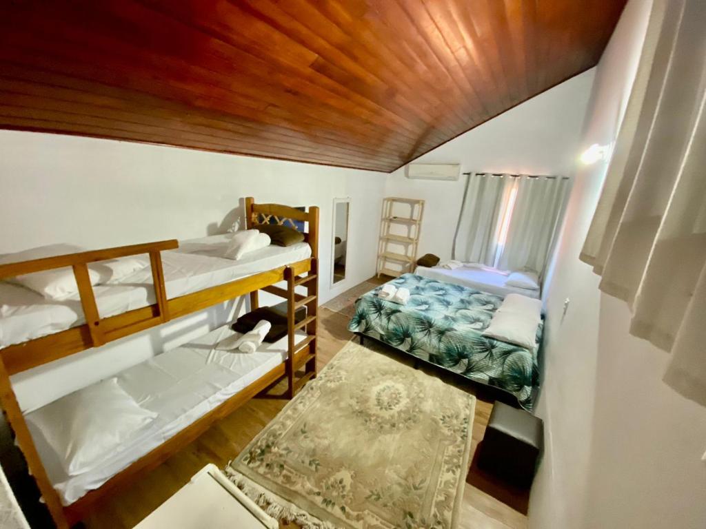 um quarto com 2 beliches e um tapete em Pousada Ponta dos Corais no Guarujá