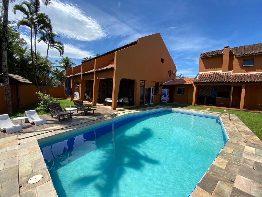 een zwembad voor een huis bij Pousada Ponta dos Corais in Guarujá
