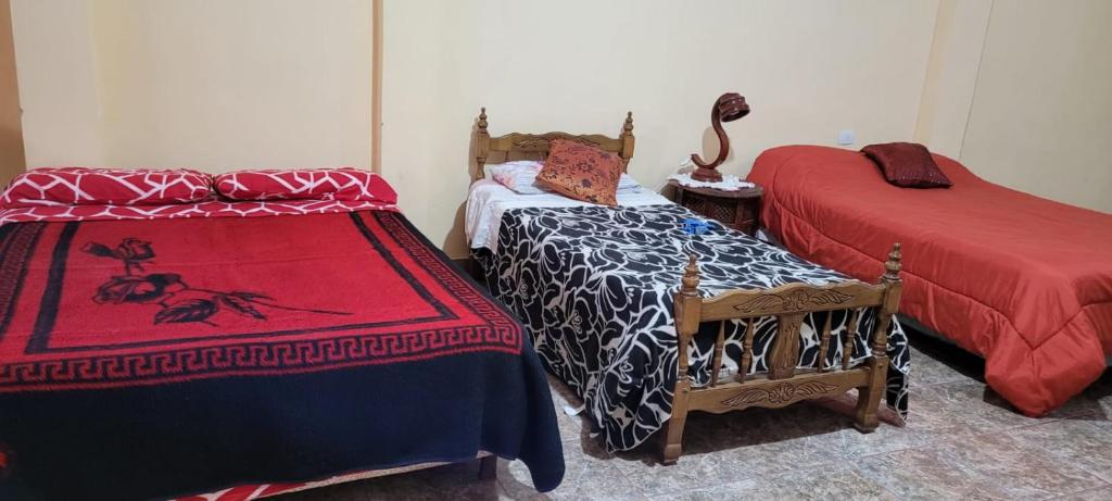 Cette chambre comprend 2 lits et une table avec un couvre-lit. dans l'établissement Kenny G, à Tinogasta